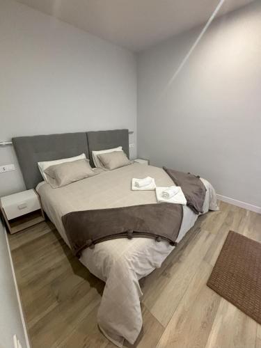 a bedroom with a large bed and a wooden floor at Apartamentos Natura Cantabria in Santillana del Mar