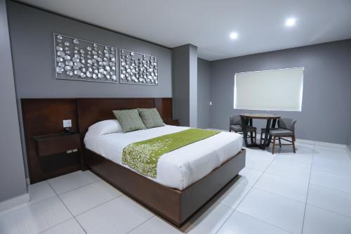 a bedroom with a bed and a table with chairs at Hotel Aqua Rio in Tijuana