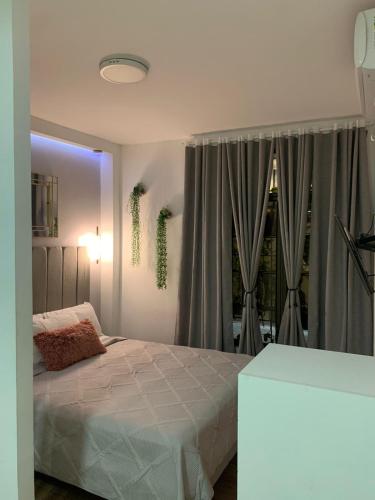 a bedroom with a white bed and a window at Los Soles Suite Mall del Sol Guayaquil Airport in Guayaquil