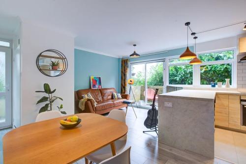 a kitchen and living room with a wooden table at Stylish quiet garden flat with parking in London Zone 4 in Bromley