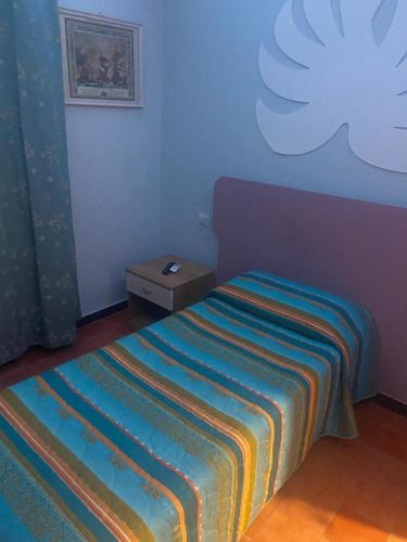a bedroom with a bed with a colorful striped blanket at Il vecchio vapore in Villalvernia