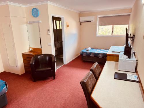 a room with a desk and a room with a bed at Blue Whale Motor Inn & Apartments in Warrnambool