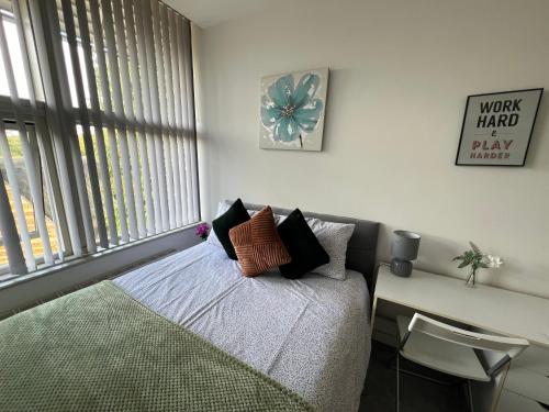 a room with a bed and a desk and a window at 3 Bedroom Flat in Town Centre in Wellingborough