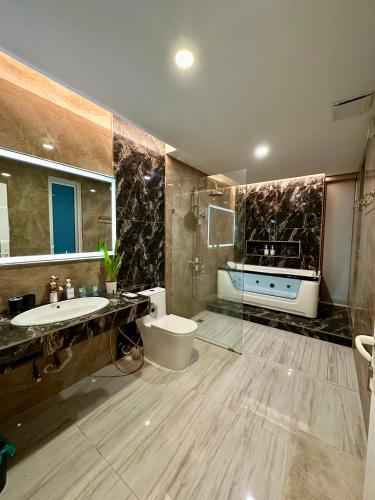 a bathroom with a sink and a toilet and a tub at Stylish villa alma in Simpang Ampat