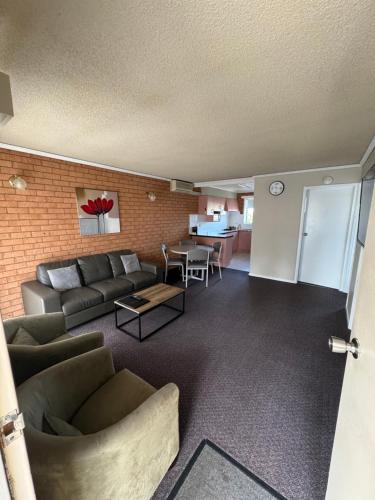 a living room with a couch and a table at Blue Whale Motor Inn & Apartments in Warrnambool