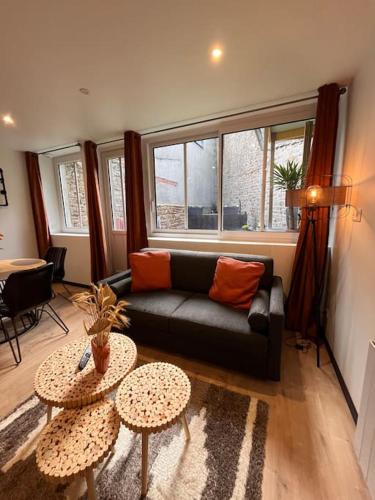 un salon avec un canapé et deux tables dans l'établissement Atelier du spa jacuzzi illimité proche du mont saint Michel, à Avranches