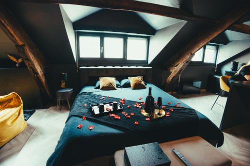 a bedroom with a bed with red roses on it at La Marble Room - Suite balnéo & sauna in Angers