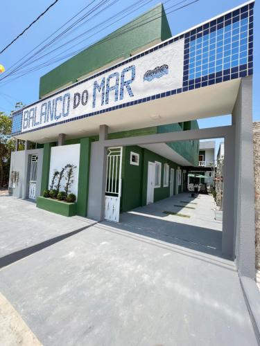a green building with a sign that reads eat emu do merc at Pousada Balanço do Mar in Prado