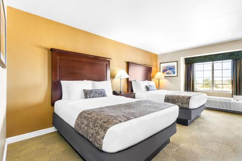 two beds in a hotel room with yellow walls at Best Western California City Inn & Suites in California City