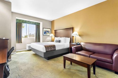 a hotel room with a bed and a couch at Best Western California City Inn & Suites in California City