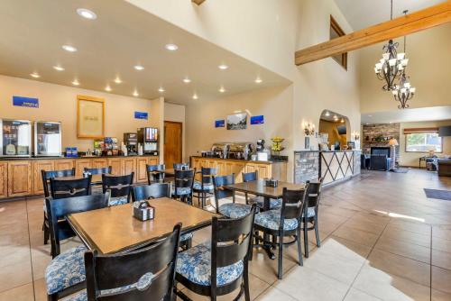 a restaurant with tables and chairs and a kitchen at Best Western Sunset Inn in Cody
