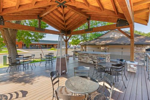 a patio with tables and chairs under a wooden roof at Best Western Sunset Inn in Cody