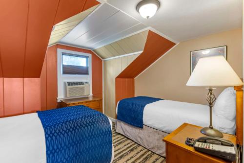 a bedroom with two beds and a table with a lamp at Best Western Sunset Inn in Cody