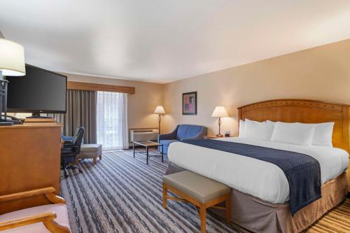 a hotel room with a bed and a flat screen tv at Best Western Sunset Inn in Cody