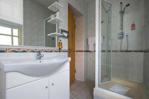 a bathroom with a sink and a shower at Best Western Buckingham Palace Rd in London
