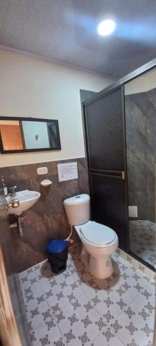 a bathroom with a toilet and a sink at Villa Montilla Cabañas Anapoima in Anapoima