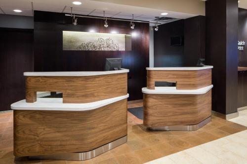 a lobby with wooden counters and a painting on the wall at Courtyard Dallas Mesquite in Mesquite