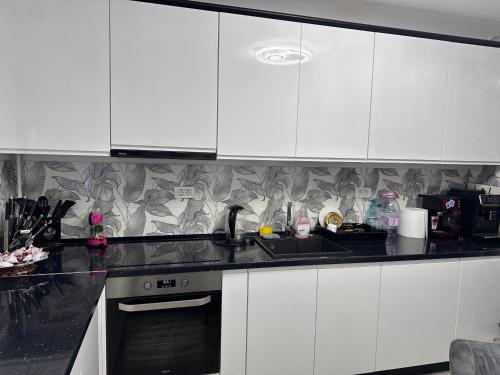 a kitchen with white cabinets and a sink at LaMaria in Caransebeş