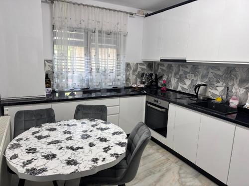 a kitchen with white cabinets and a table and chairs at LaMaria in Caransebeş