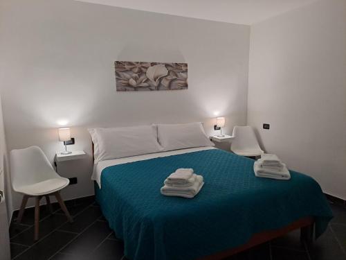 a bedroom with a bed with two chairs and two lamps at Casa gialla in LʼAquila