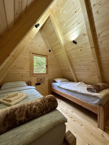 a bedroom with two beds in a wooden attic at Plivska vila 1 in Jajce