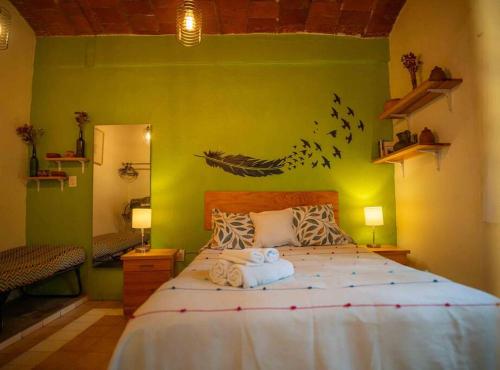 a bedroom with a large bed with birds on the wall at chill green beautiful downtown area TV good Wifi in Oaxaca City