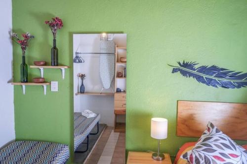 a green room with a bed and a mirror at chill green beautiful downtown area TV good Wifi in Oaxaca City