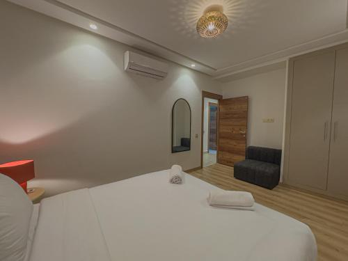 a bedroom with a large white bed and a chair at TheCasaEdition - Gueliz Residency in Marrakech