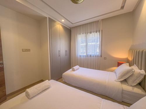a hotel room with two beds and a window at TheCasaEdition - Gueliz Residency in Marrakech