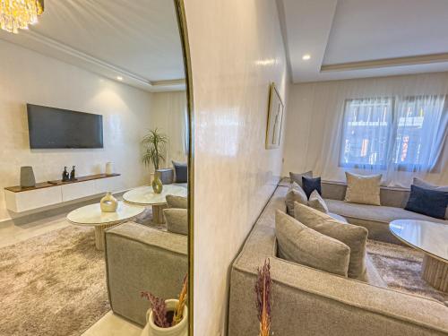 a living room with a couch and a tv at TheCasaEdition - Gueliz Residency in Marrakech