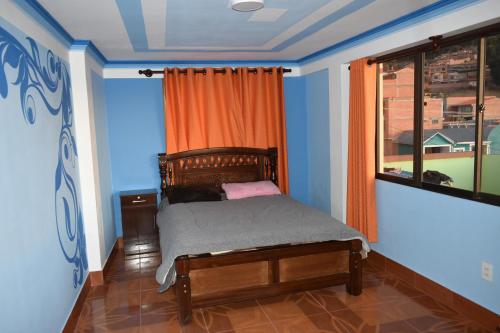 a small bedroom with a bed with an orange curtain at Backpacker Nexus Mirasol in Copacabana