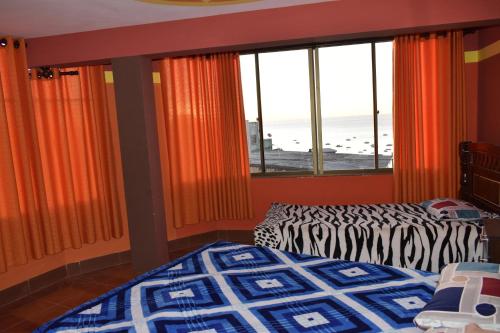 a bedroom with two beds and a large window at Backpacker Nexus Mirasol in Copacabana