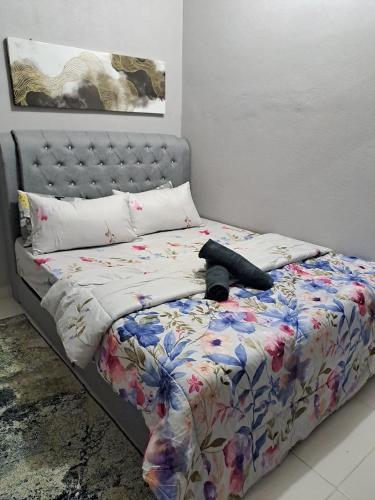 una cama con un objeto negro sobre ella en Homestay Bajet Machang - Lycaste, en Kampong Batu