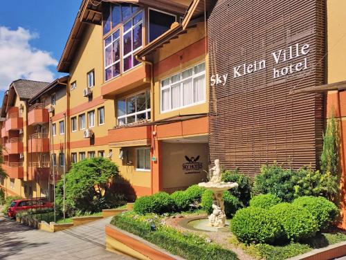 a building with a fountain in front of it at Sky Ville Hotel Canela in Canela