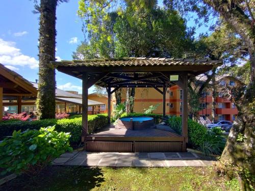 a wooden gazebo with a pool in a yard at Sky Ville Hotel Canela in Canela