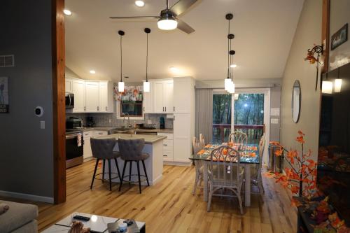 a kitchen with white cabinets and a table and chairs at Long pond, Pocono pines quiet & cozy!Kalahari 8mins in Pocono Pines