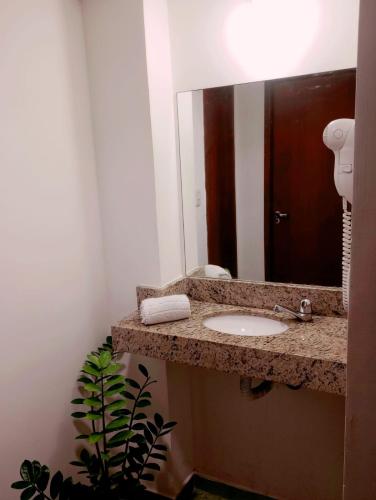 a bathroom with a sink and a mirror at Flats Via Mar in Macaé