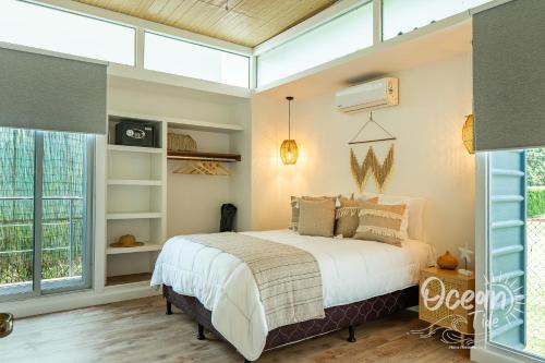 a bedroom with a bed and a large window at Oceantide Playa Hermosa in Playa Hermosa