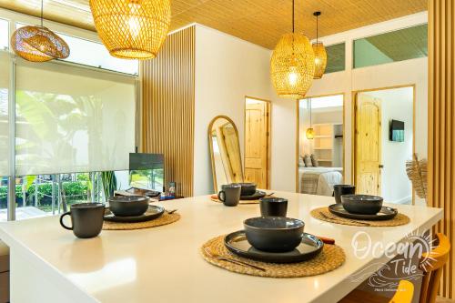 a kitchen with a table with cups and dishes on it at Oceantide Playa Hermosa in Playa Hermosa