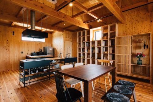 a dining room with a table and a piano at 縹茫-Hyoubou- in Mitoyo