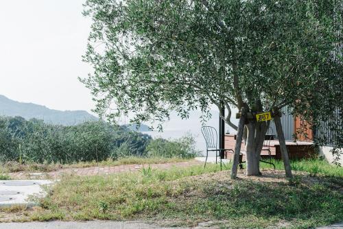 a tree with a sign on it next to a house at 縹茫-Hyoubou- in Mitoyo