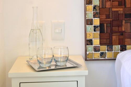 a table with two glasses and a bottle on it at Unic Design Hotel & Restaurant- 5th Avenue in Playa del Carmen