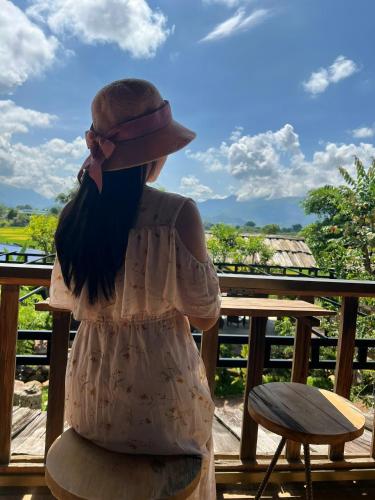 a girl sitting on a rock looking at the sky at Trần Gia Homestay in Văn Chấn