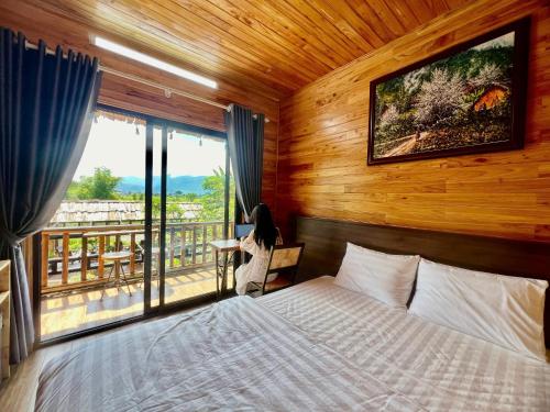 a bedroom with a bed and a window with a view at Trần Gia Homestay in Văn Chấn