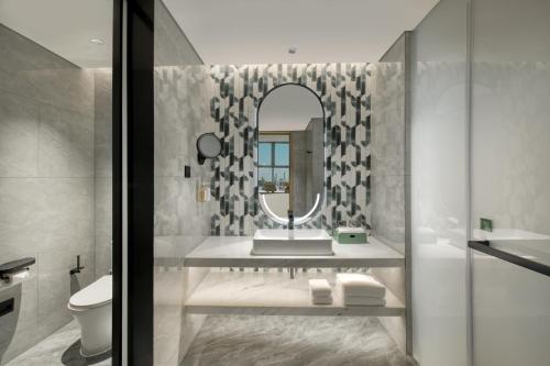 a bathroom with a sink and a mirror at Holiday Inn Shenzhen Nanshan by IHG in Shenzhen