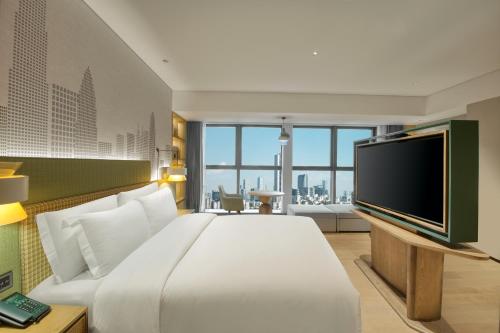 a hotel room with a large bed and a flat screen tv at Holiday Inn Shenzhen Nanshan by IHG in Shenzhen