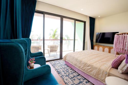 a bedroom with a bed and a tv and a balcony at Happy Stay Resort Wonderland Ho Tram in Xuyên Mộc