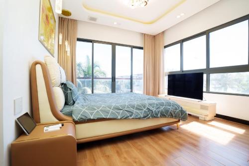a bedroom with a bed and large windows at Happy Stay Resort Wonderland Ho Tram in Xuyên Mộc