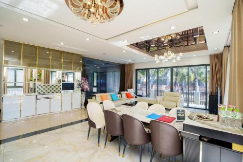 a dining room and living room with a table and chairs at Happy Stay Resort Wonderland Ho Tram in Xuyên Mộc