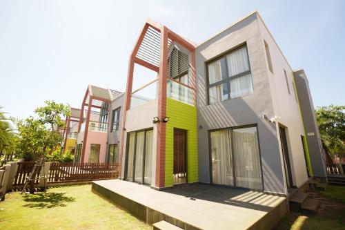a house with a green and white at Happy Stay Resort Wonderland Ho Tram in Xuyên Mộc